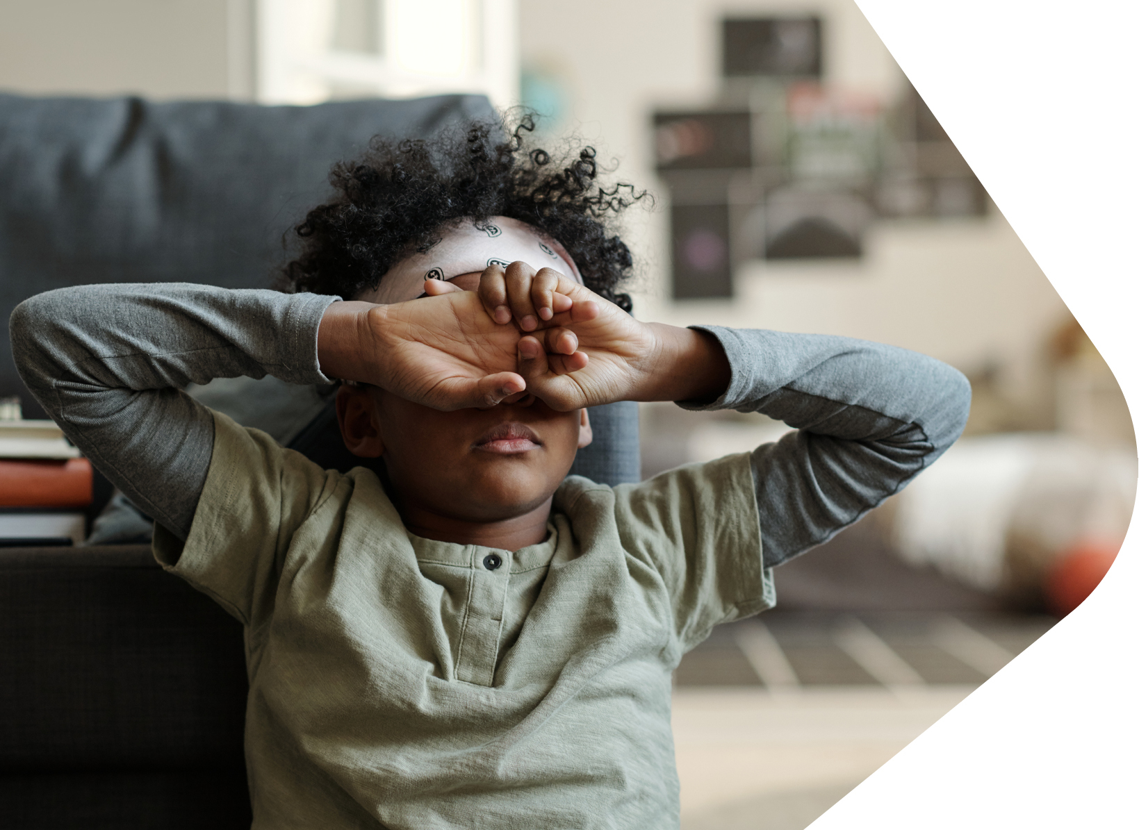 Sad African child with both hands covering his face