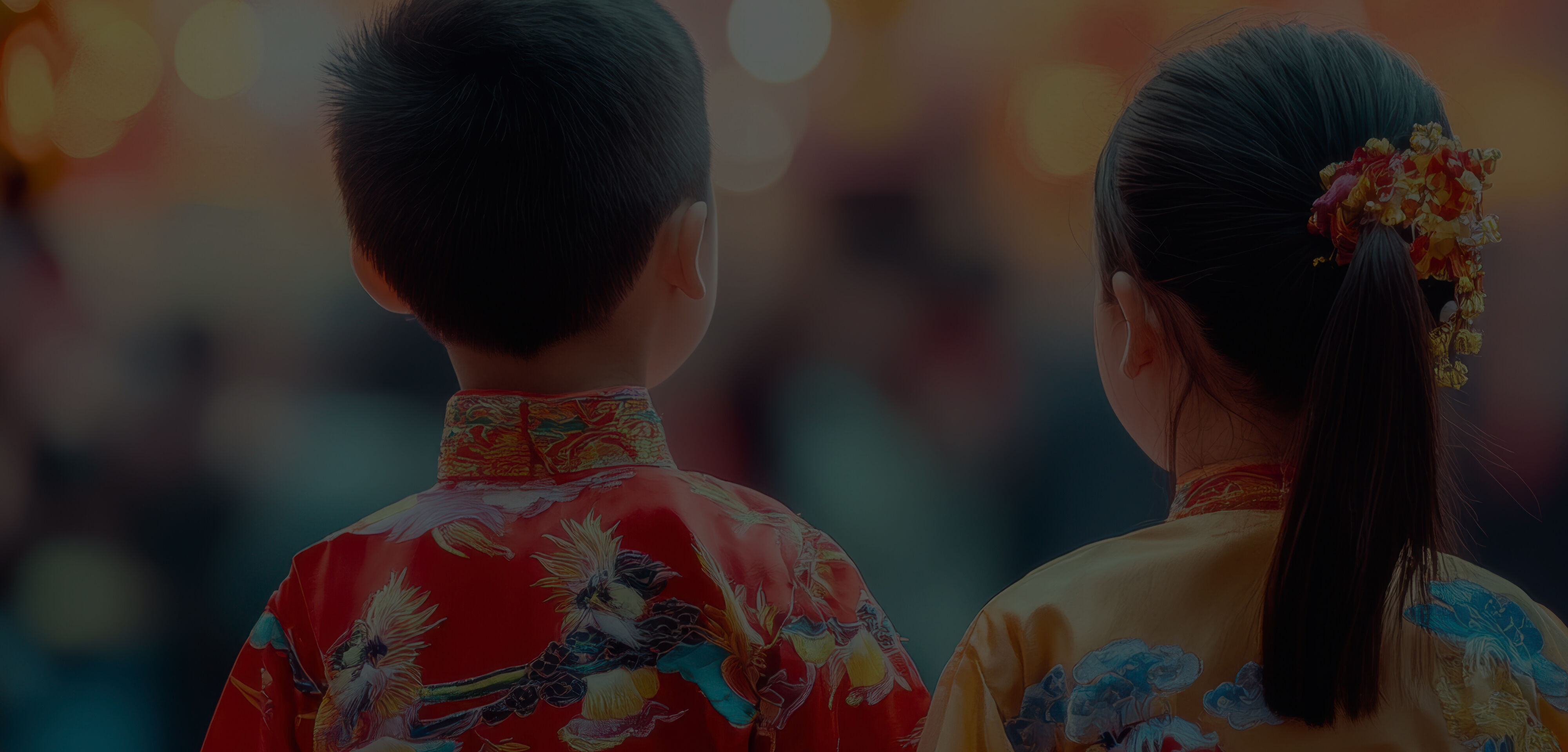 Two young asian, possibly Chines girl and boy, stand with their backs to us wearing traditional Chinese costumes