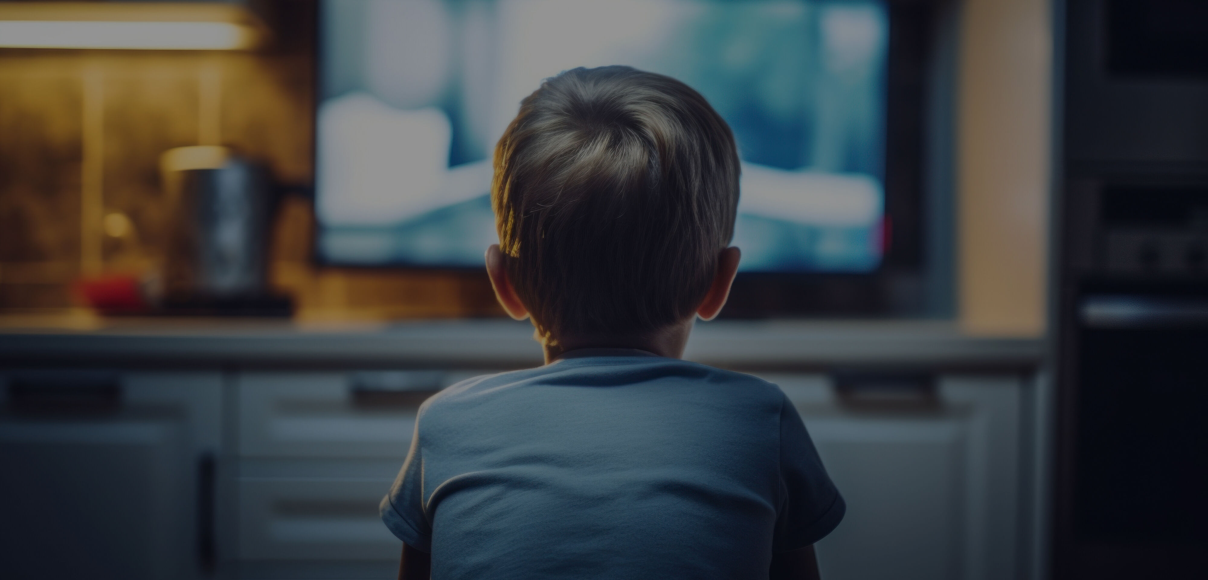 Young child sits alone on the floor watching TV