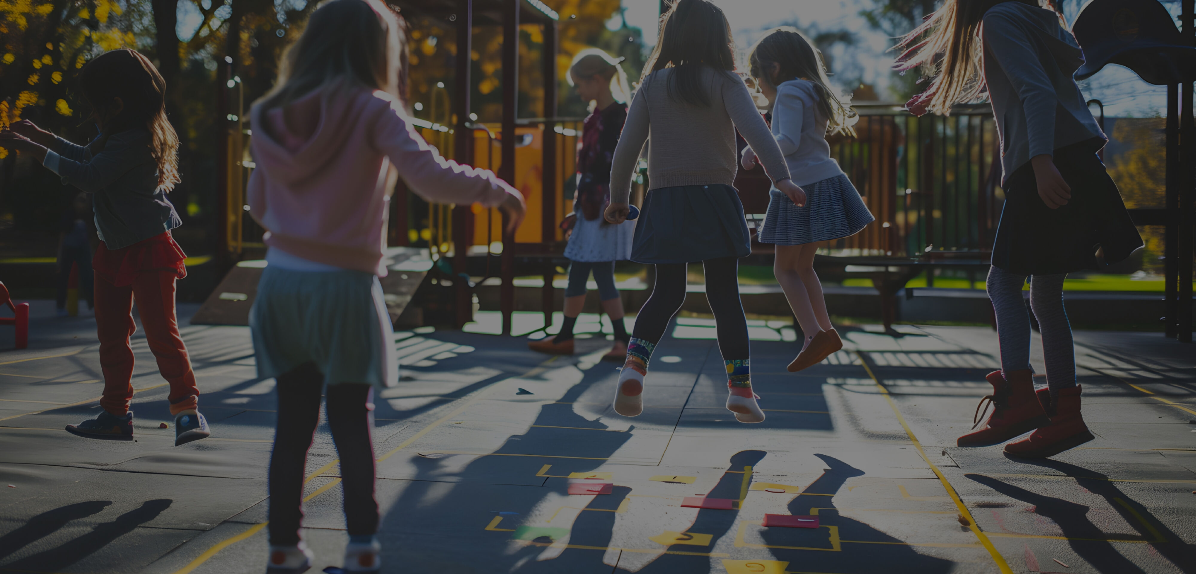 Young children in a playground all jumping and dancing in unison